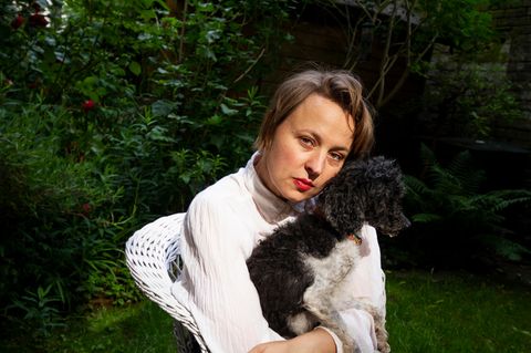 Portrait der Schauspielerin Katja Danowski in ihrem Garten mit Hund Frido