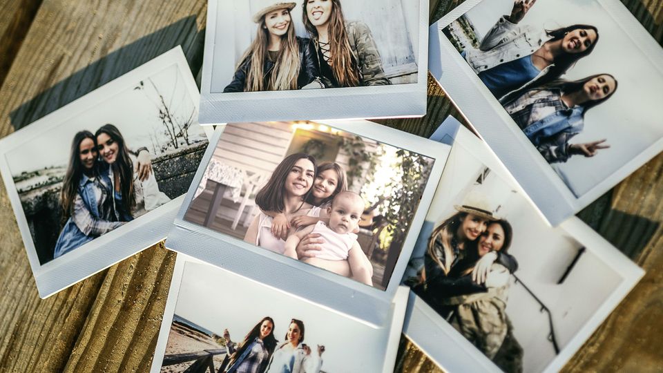 Symbolbild Ghosting: Polaroid Fotos von zwei Jungen Mädchen und in der Mitte von einer Mutter mit ihren zwei Töchtern
