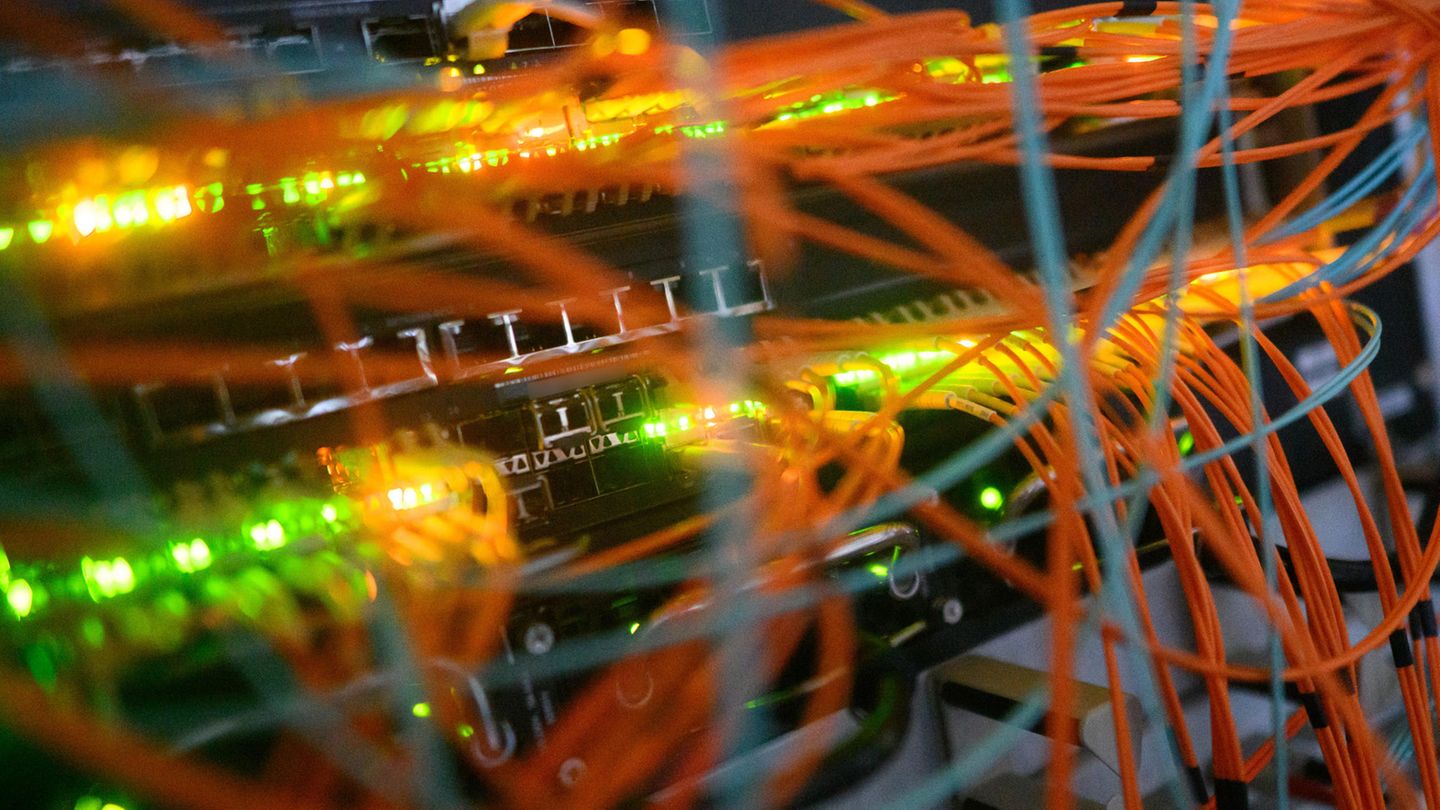 Ein Serverschrank mit blinkenden Lampen und Kabeln Ein Serverschrank mit blinkenden Lampen und Kabeln