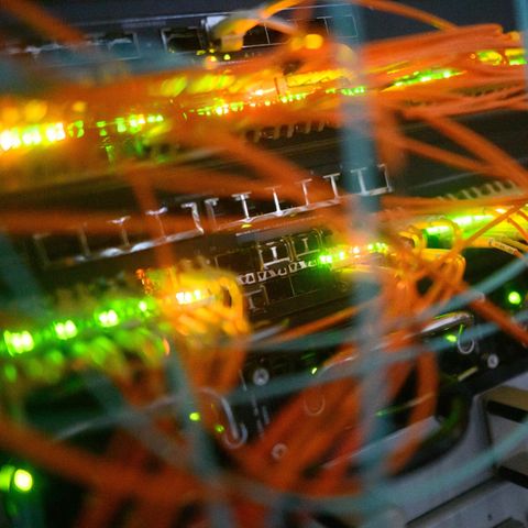 Ein Serverschrank mit blinkenden Lampen und Kabeln Ein Serverschrank mit blinkenden Lampen und Kabeln