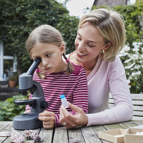 Mutter und Tochter sitzen zusammen am Mikroskop