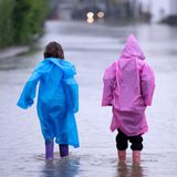 Ein bisschen Spaß muss auch mitten im Ausnahmezustand möglich sein. Die zwei Kinder haben sich passend ausgerüstet und waten über eine geflutete Straße in Dasing im schwäbischen Landkreis Aichach-Friedberg. Noch ist keine Entspannung angesagt, Stakrtregen und Gewitter werden auch am Sonntag über Brandenburg, Thüringen, Sachsen, Bayern und Baden-Württemberg hinwegziehen.