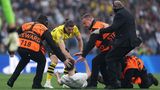 Kurz nach Beginn der Partie, war dann jedoch erstmal für ein paar Minuten Schluss mit Fußballspielen. Gleich mehrere Flitzer stürmten den Platz, einen von ihnen stoppte BVB-Profi Marcel Sabitzer höchstpersönlich.