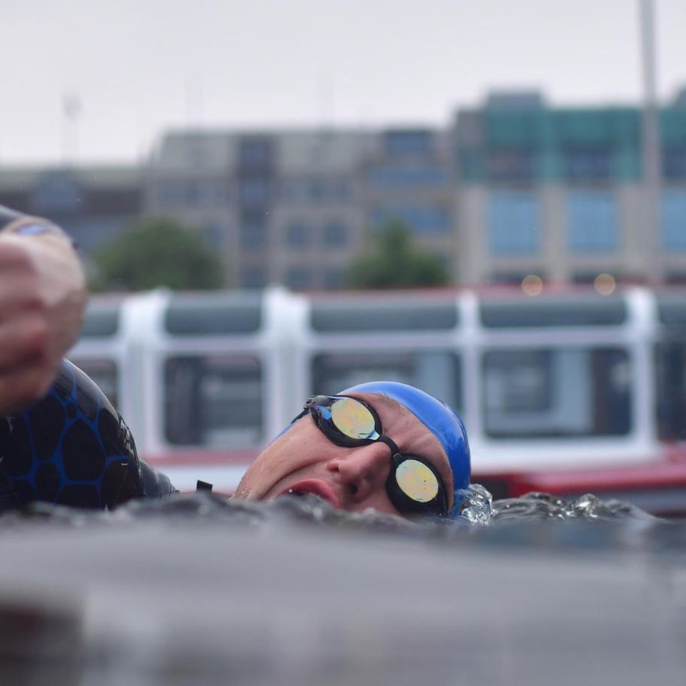 Hamburg, Deutschland. Wer hält sich nicht gerne an der Binnenalster in Hamburg auf? Wasser und Springbrunnen, Boote, Backstuben, Cafés und Kaufhäuser – alles auf einmal. Dieser Schwimmer hat dafür keinen Blick. Er nimmt am Ironman teil. Sightseeing lässt sich damit eher nicht verbinden.