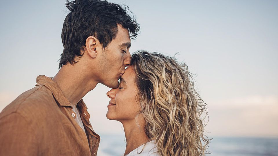 Symbolbild Liebe: Ein Mann küsst eine Frau auf die Stirn