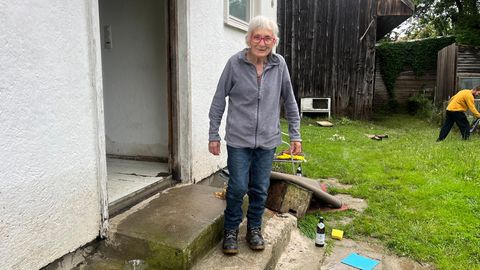 Seniorin vor ihrem Haus