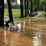 Ein Radfahrer watet durch das Hochwasser im Körschtal bei Stuttgart Plieningen