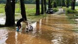 Ein Radfahrer watet durch das Hochwasser im Körschtal bei Stuttgart Plieningen
