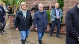 Olaf Scholz geht mit der saarländischen Ministerpräsidentin Anke Rehlinger (SPD) in Gummistiefel durch das Hochwasser