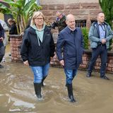 Olaf Scholz geht mit der saarländischen Ministerpräsidentin Anke Rehlinger (SPD) in Gummistiefel durch das Hochwasser