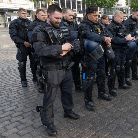 Minuten nach dem Bekanntwerden seines Todes trauern Polizisten auf dem Marktplatz in Mannheim um ihren getöteten Kollegen