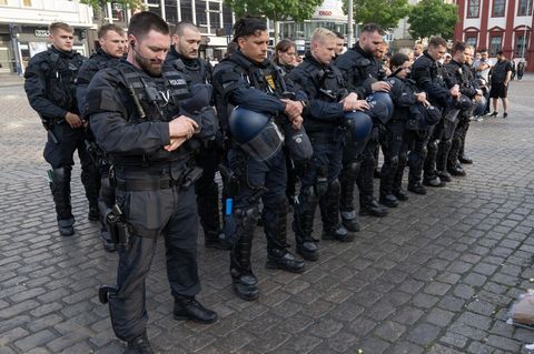 Minuten nach dem Bekanntwerden seines Todes trauern Polizisten auf dem Marktplatz in Mannheim um ihren getöteten Kollegen