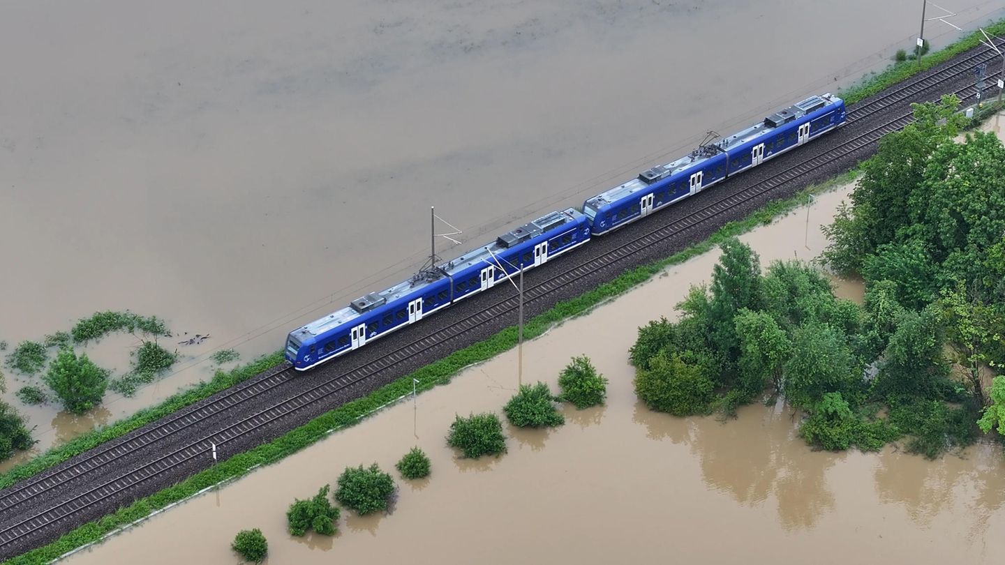 Ein Zug fährt über den höher gelegenen Bahndamm: Das Hochwasser der Schussen überschwemmt Teile von Meckenbeuren in Baden-Württemberg