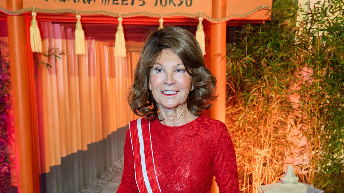 Brigitte Bierlein steht in rotem langen Kleid auf dem Juristenball 2024 in Wien, Österreich