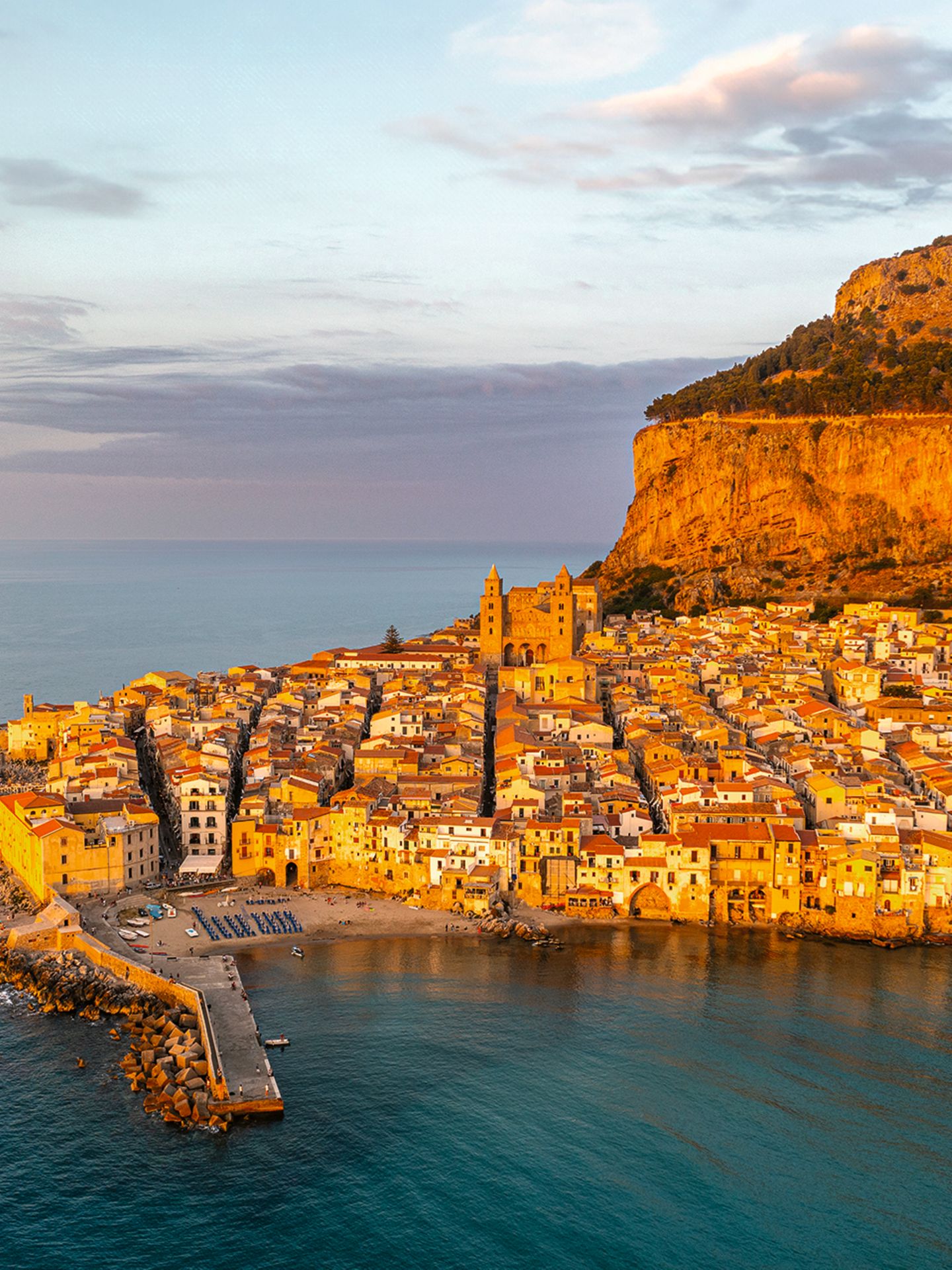 Zugegeben, in Cefalù boomt der Tourismus. Nachts beben die Gassen der verwinkelten Altstadt im Beat der Bars und Restaurants, in denen sich Einheimische wie Gäste gleichermaßen tummeln. In der näheren Umgebung gibt es viele Möglichkeiten, die Natur beim Wandern oder Radfahren zu erkunden, an den ortseigenen Stränden kann man sie Seele baumeln und sich die Sonne auf den Bauch scheinen lassen – und nachmittags durch die vielen kleinen Lädchen in der Altstadt schlendern. 