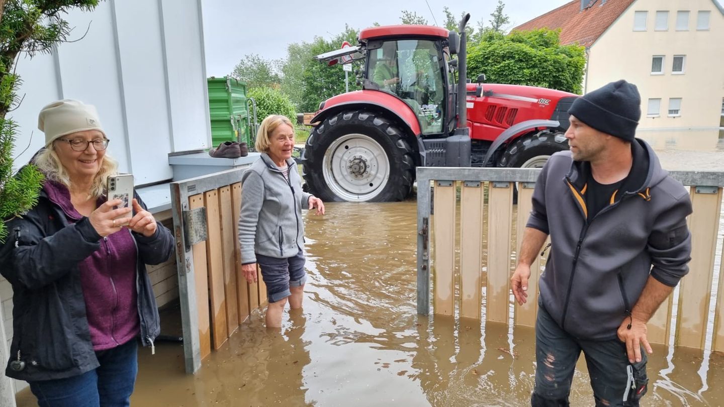 Elisabeth Pichler, Sabine Cerhak und ein Nachbar stehen im Wasser