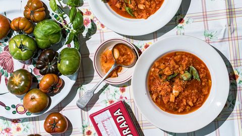 Tomatensuppe angerichtet neben frischen Tomaten