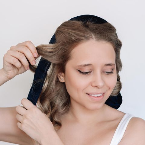 Eine Frau macht sich Locken ohne Hitze.
