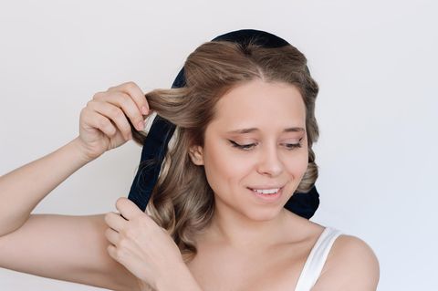 Eine Frau macht sich Locken ohne Hitze.