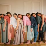 Frauen stehen in einer Reihe und legen ihren Kopf auf dem Rücken der vorherigen ab