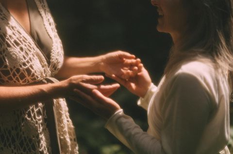 Zwei Frauen halten sich an den Händen