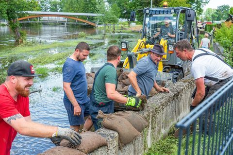 Nach dem Hochwasser: Helfer beseitigen Sandsäcke auf Staumauer