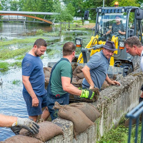Nach dem Hochwasser: Helfer beseitigen Sandsäcke auf Staumauer