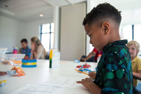 Kinder sitzen über einer Mathematikaufgabe im Klassenzimmer