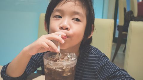 Thema Süßstoffe: Kind trinkt Cola aus einem Glas