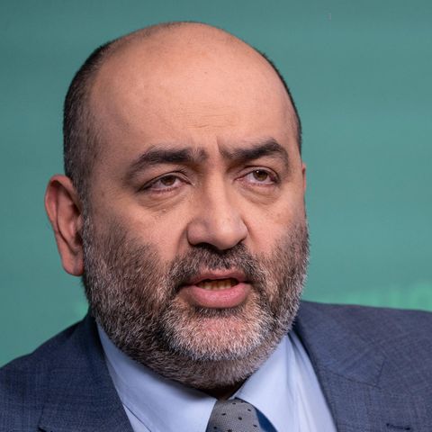 Porträt des Grünen-Co-Vorsitzenden Omid Nouripour vor Stellwand mit grünem Parteilogo