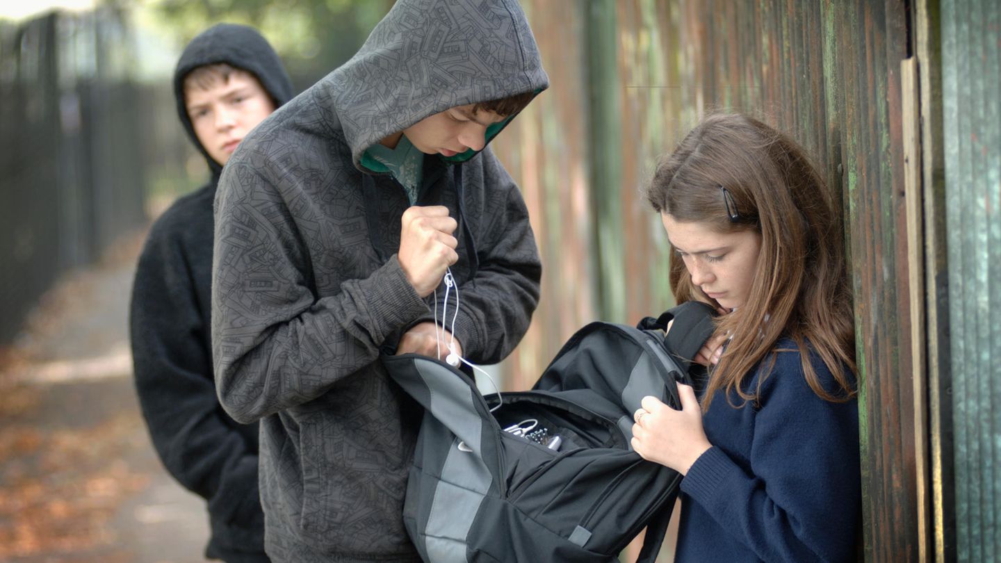 Mobbing Ein Mädchen wird von zwei jungen bedrängt und bestohlen