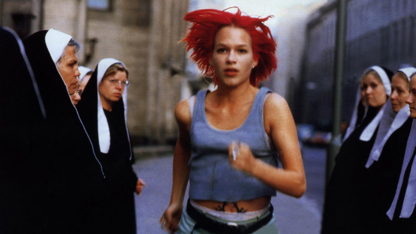 Lola Rennt: Schauspielerin Franka Potente mit rot gefärbten Haaren rennt vor einer Gruppe Nonnen davon