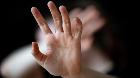 Häusliche Gewalt: Eine nicht erkennbare Frau hält ihre Hände vor das Gesicht