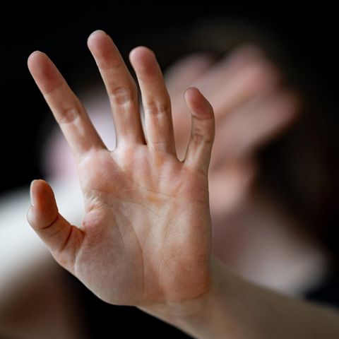 Häusliche Gewalt: Eine nicht erkennbare Frau hält ihre Hände vor das Gesicht