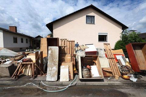 Vom Hochwasser zerstörte Gegenstände stehen vor einem Wohnhaus im bayerischen Baar-Ebenhausen