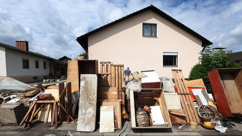 Vom Hochwasser zerstörte Gegenstände stehen vor einem Wohnhaus im bayerischen Baar-Ebenhausen