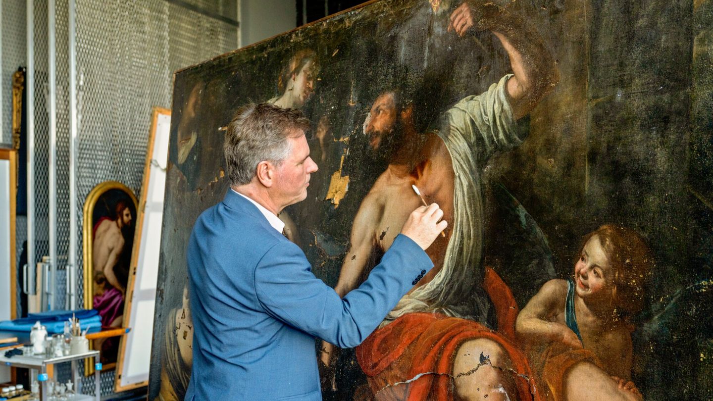 Ein Restaurator reinigt die beschädigte Oberfläche des Gemäldes "Herkules und Omphale"