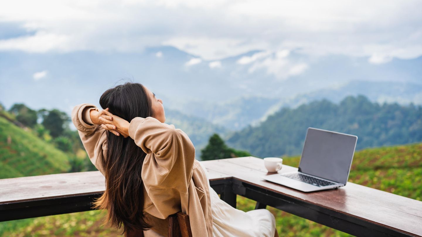 Frau mit Laptop in den Bergen