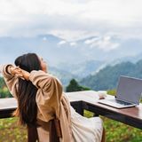 Frau mit Laptop in den Bergen