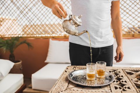 Ein junger Mann schenkt marokkanischen Tee ein