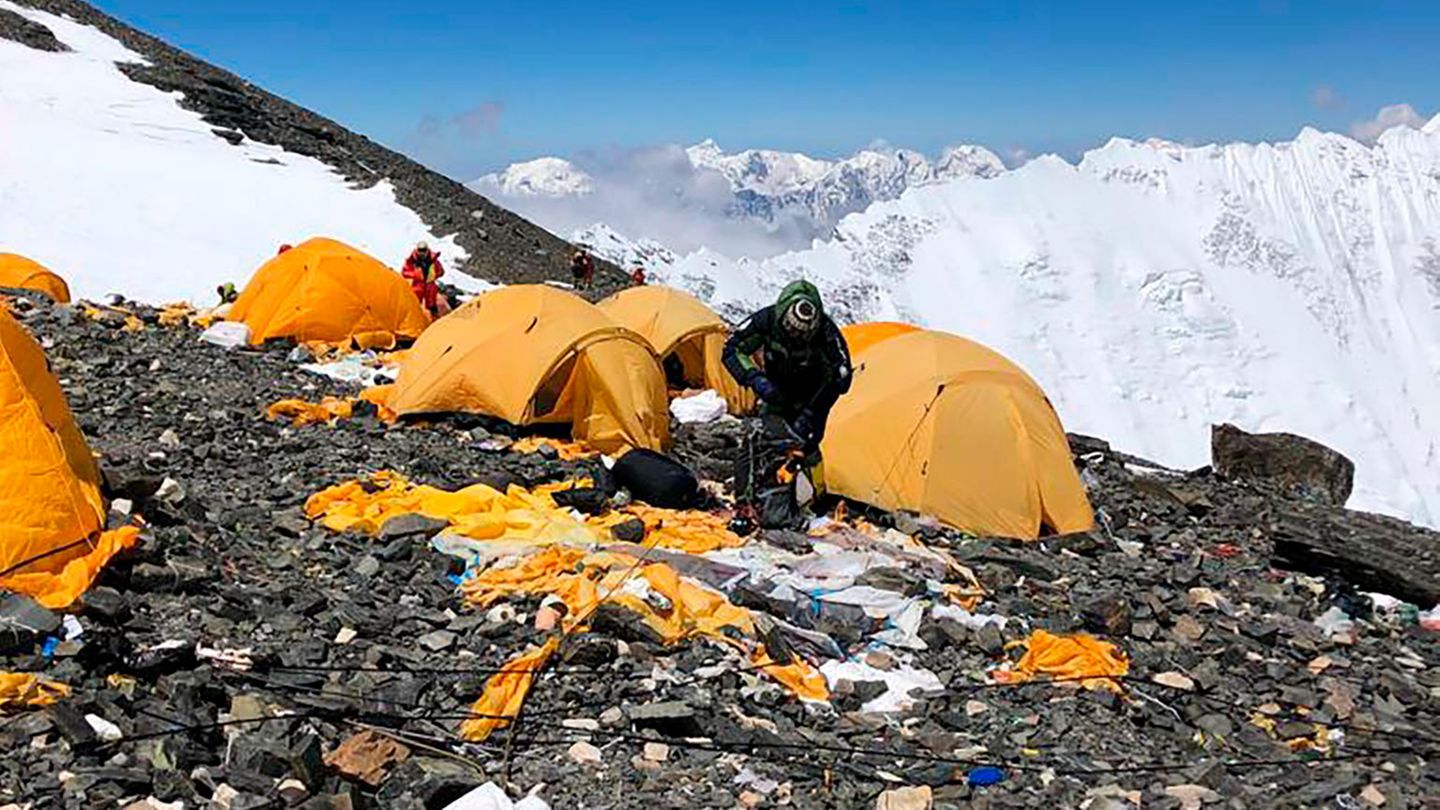 Sherpa gehen durch ein verlassenes Zeltlager am Mount Everest