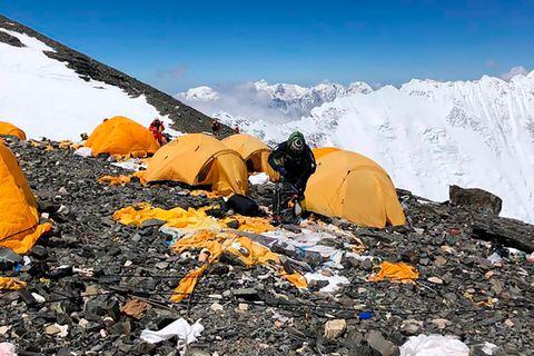 Sherpa gehen durch ein verlassenes Zeltlager am Mount Everest