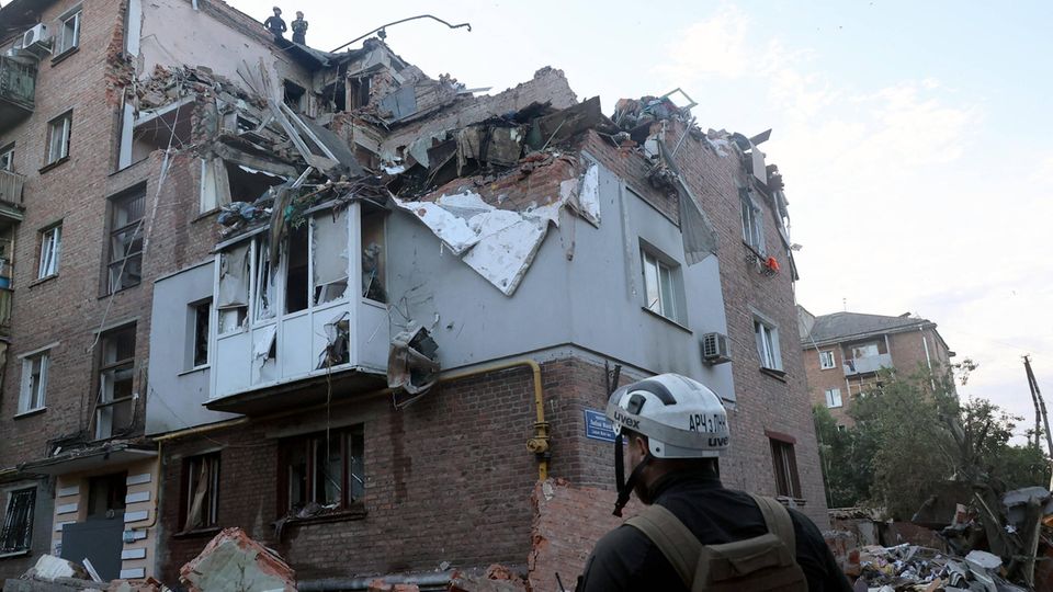 Helfer bei einem zerstörten Haus in Charkiw in der Ukraine