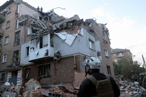 Helfer bei einem zerstörten Haus in Charkiw in der Ukraine