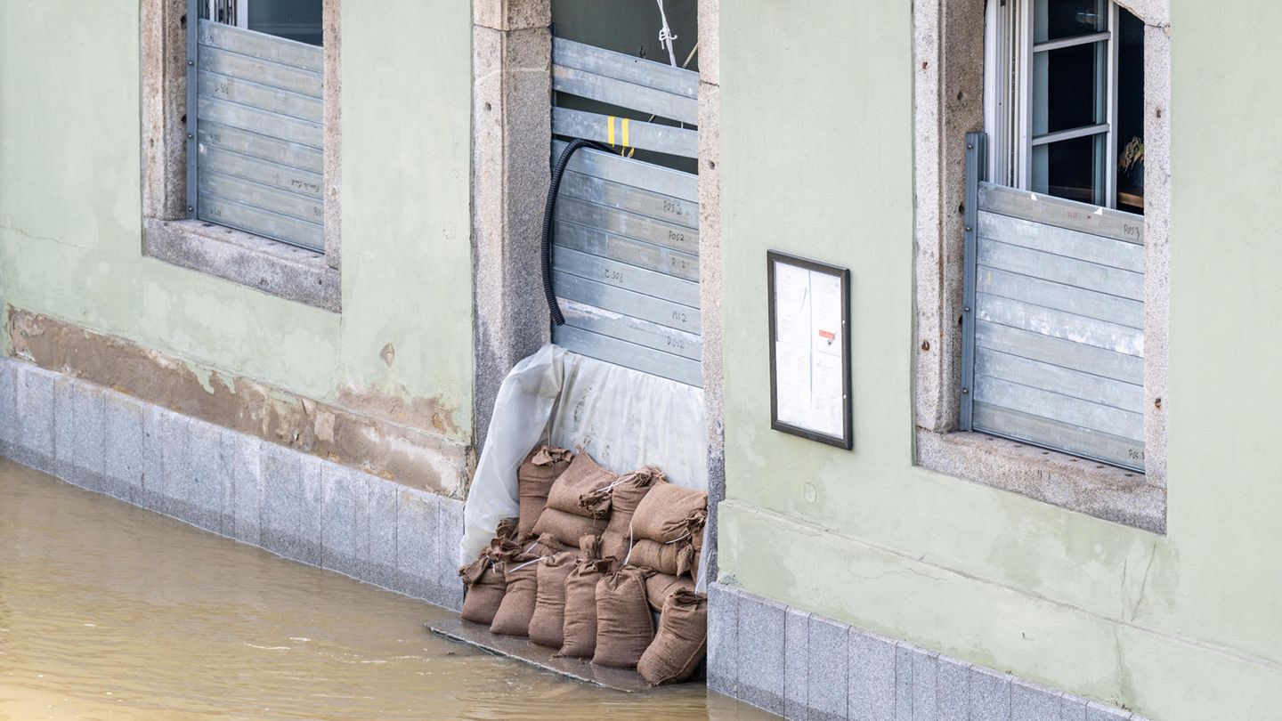 Pflichtversicherung ja oder nein? Ein Haus im Hochwasser, das mit Sandsäcken geschützt ist