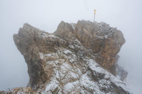 Der Gipfel der Zugspitze mit Gipfelkreuz liegt im Nebel