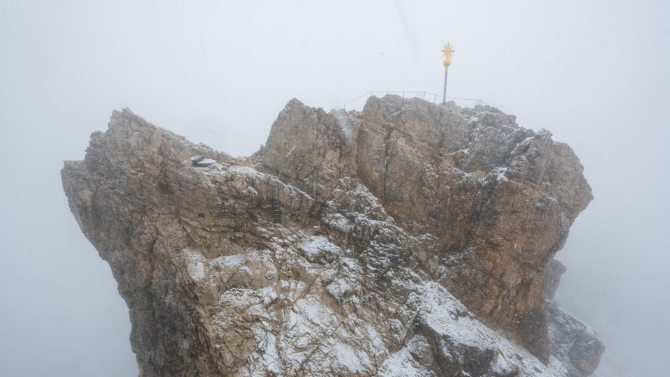 Der Gipfel der Zugspitze mit Gipfelkreuz liegt im Nebel