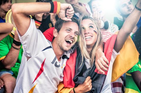 Geschenkideen für Fußballfans: Deutschland-Anhänger jubeln mit Trikot und Fahne