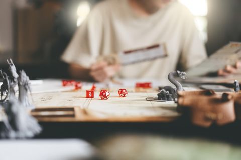 Würfel und Spielfiguren liegen auf einem Rollenspiel-Brettspiel