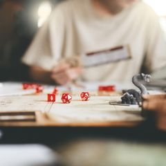 Würfel und Spielfiguren liegen auf einem Rollenspiel-Brettspiel